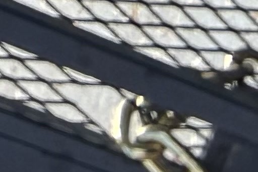 Close-up of a chain and lock securing a chain-link fence gate