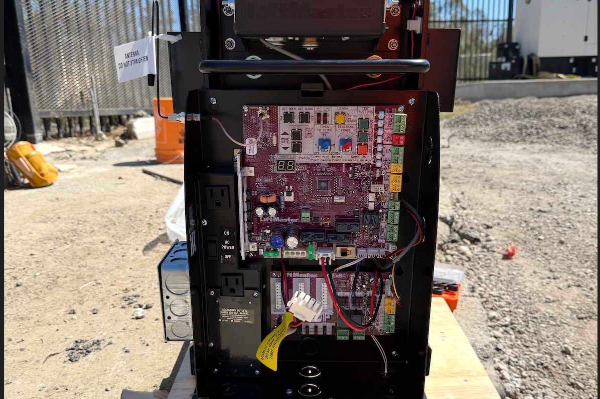 LiftMaster gate operator with its control board open for programming on site