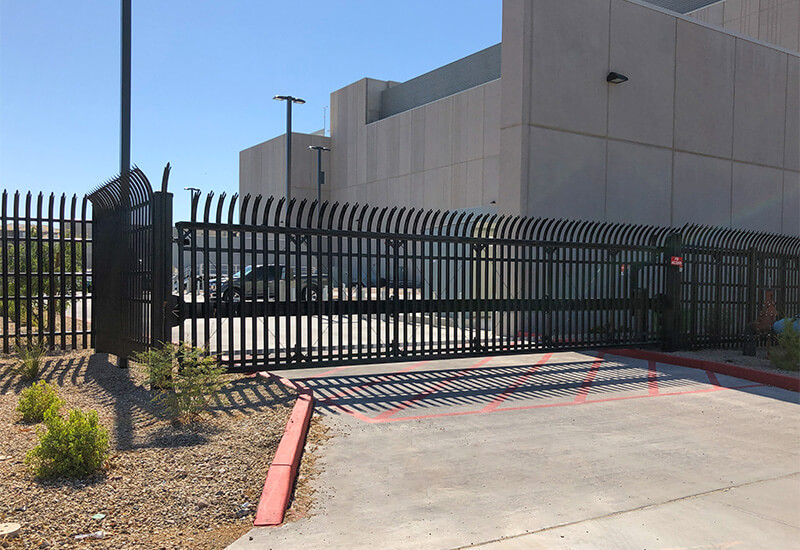 Black steel cantilever slide gate at a commercial warehouse entrance