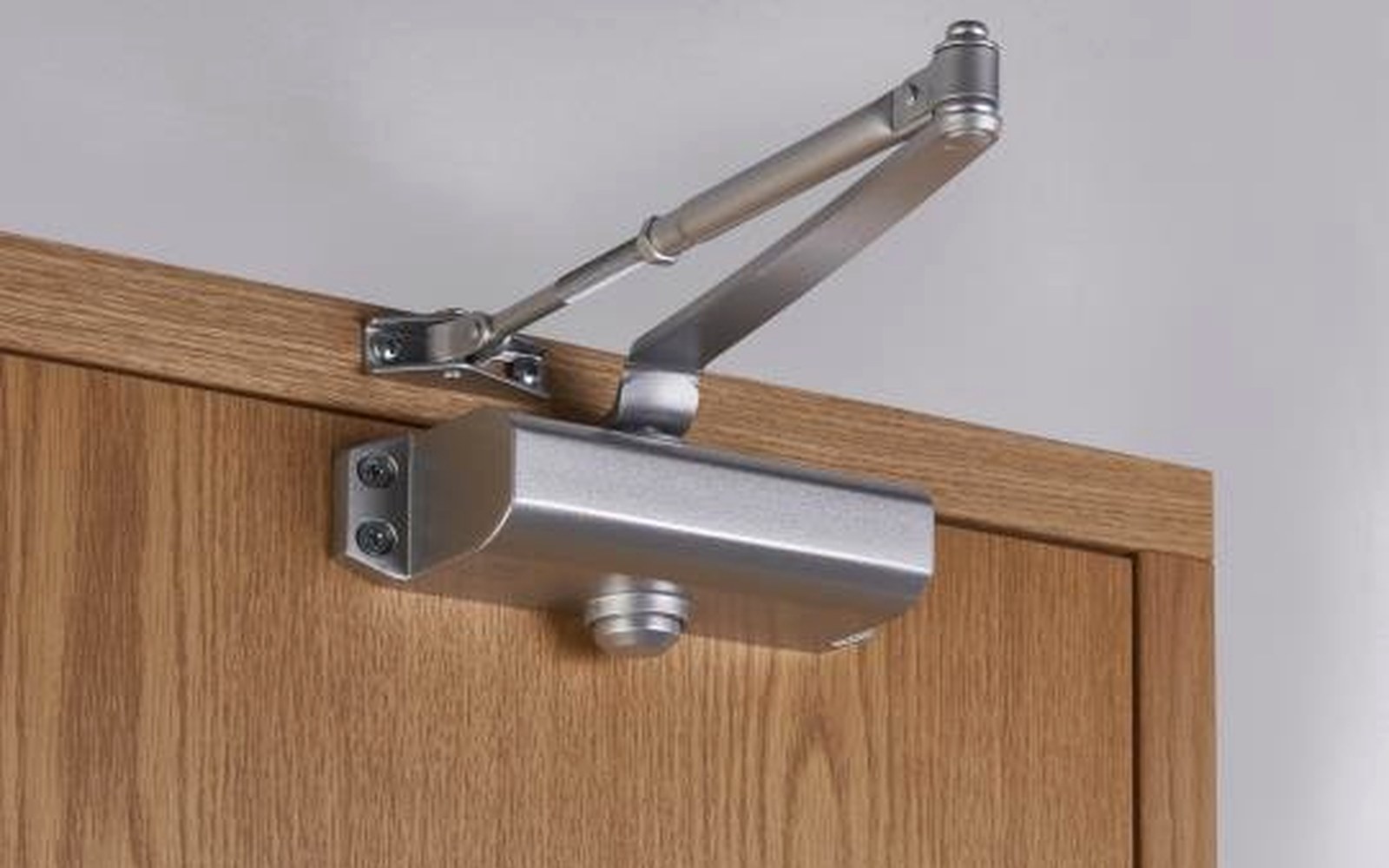 Hydraulic self-closing hinge mounted between a metal gate leaf and its post