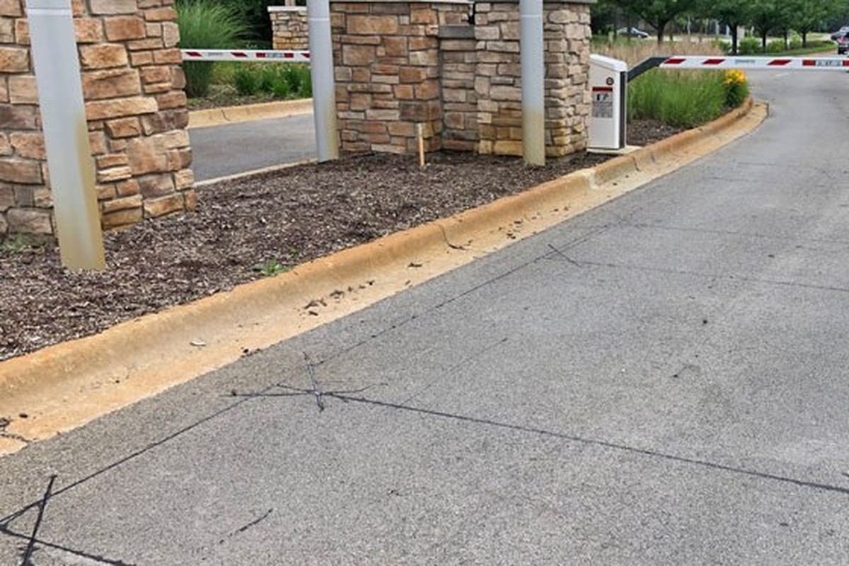 Commercial entry drive with stone pillars, barrier posts and vehicle detection loops