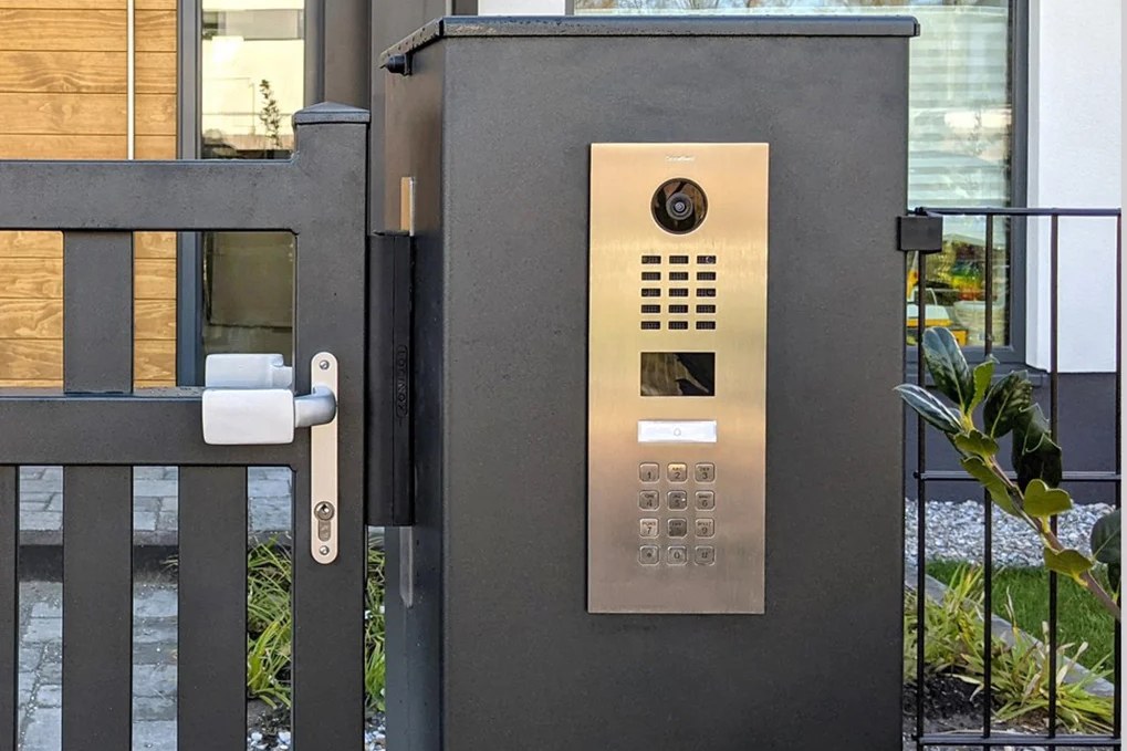 Pedestrian gate with a video intercom station mounted on the entry column