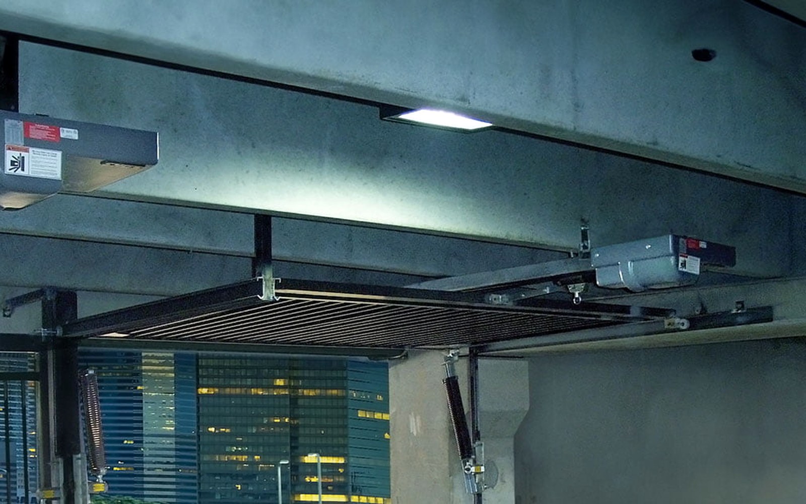 Overhead gate operator with drive assembly mounted above a steel mesh vehicle gate