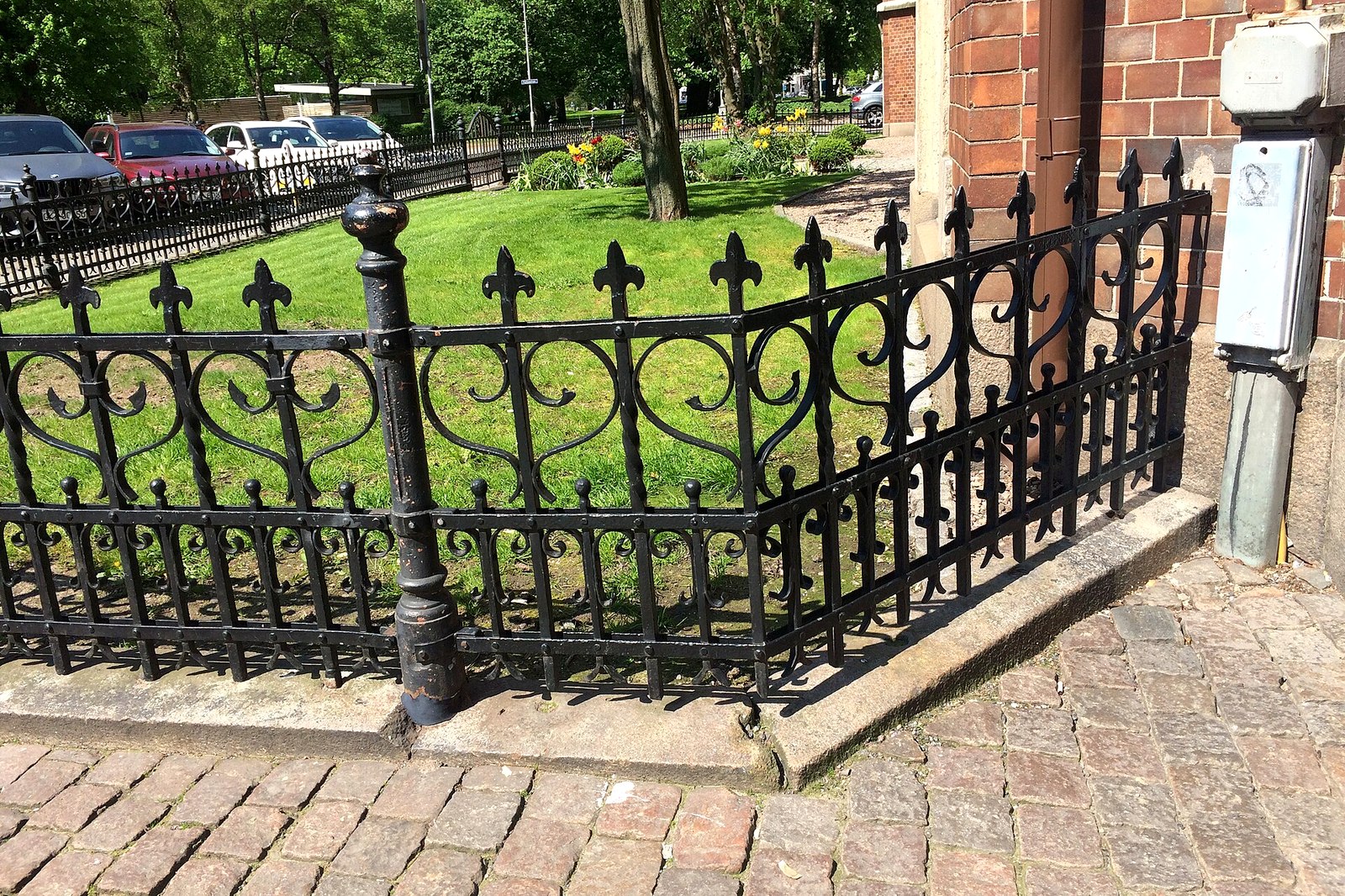 Black wrought iron fence with decorative finials along a property line